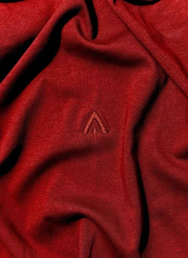 Close-up of a red fabric with a small embroidered logo.
